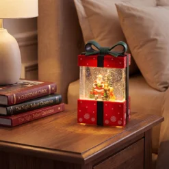Lanterna Pacco Regalo rosso con glitter scintillanti, h 19 cm, led bianco caldo, musiche natalizie