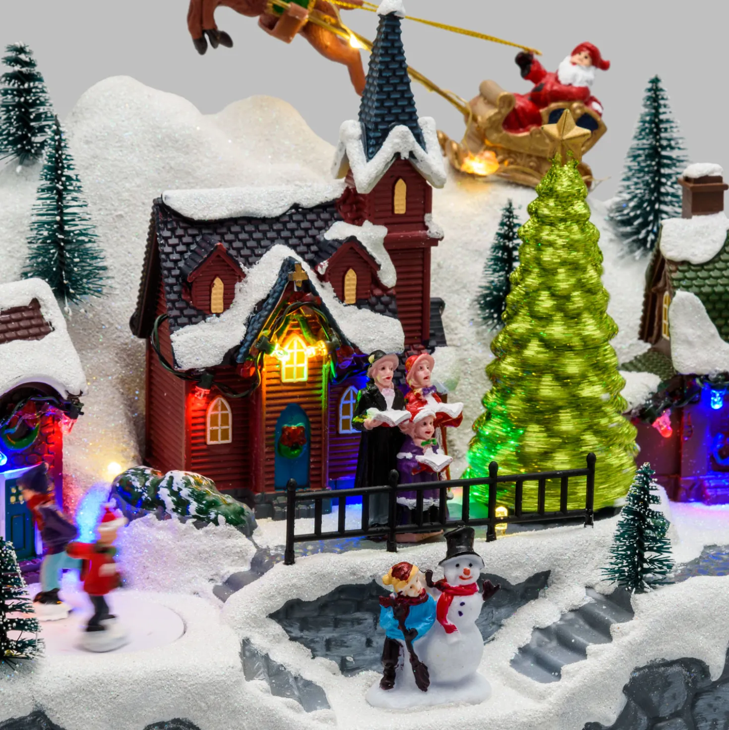 Paesaggio natalizio con Babbo Natale su slitta volante e pattinatori in movimento, led multicolor