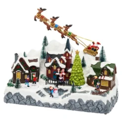 Paesaggio natalizio con Babbo Natale su slitta volante e pattinatori in movimento, led multicolor
