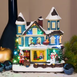 Villaggio di Natale, Casa con scena natalizia, Slitta in movimento e Albero di Natale RGB, h 23 cm, musiche natalizie