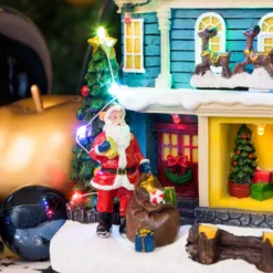 Villaggio di Natale, Casa con scena natalizia, Slitta in movimento e Albero di Natale RGB, h 23 cm, musiche natalizie