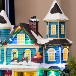Villaggio di Natale, Casa con scena natalizia, Slitta in movimento e Albero di Natale RGB, h 23 cm, musiche natalizie
