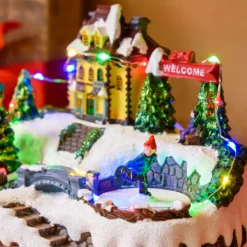 Villaggio di Natale in Polyresina, Pattinatore e Albero Natale con Bambini rotanti, h 15 cm