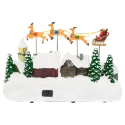 Villaggio Innevato con Chiesa e Babbo Natale su Slitta Volante con Renne in movimento, h 23 cm, musiche natalizie