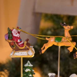Villaggio Innevato con Chiesa e Babbo Natale su Slitta Volante con Renne in movimento, h 23 cm, musiche natalizie