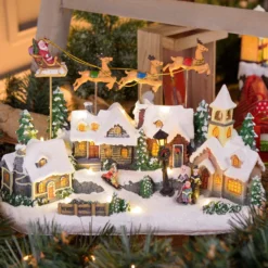 Villaggio Innevato con Chiesa e Babbo Natale su Slitta Volante con Renne in movimento, h 23 cm, musiche natalizie